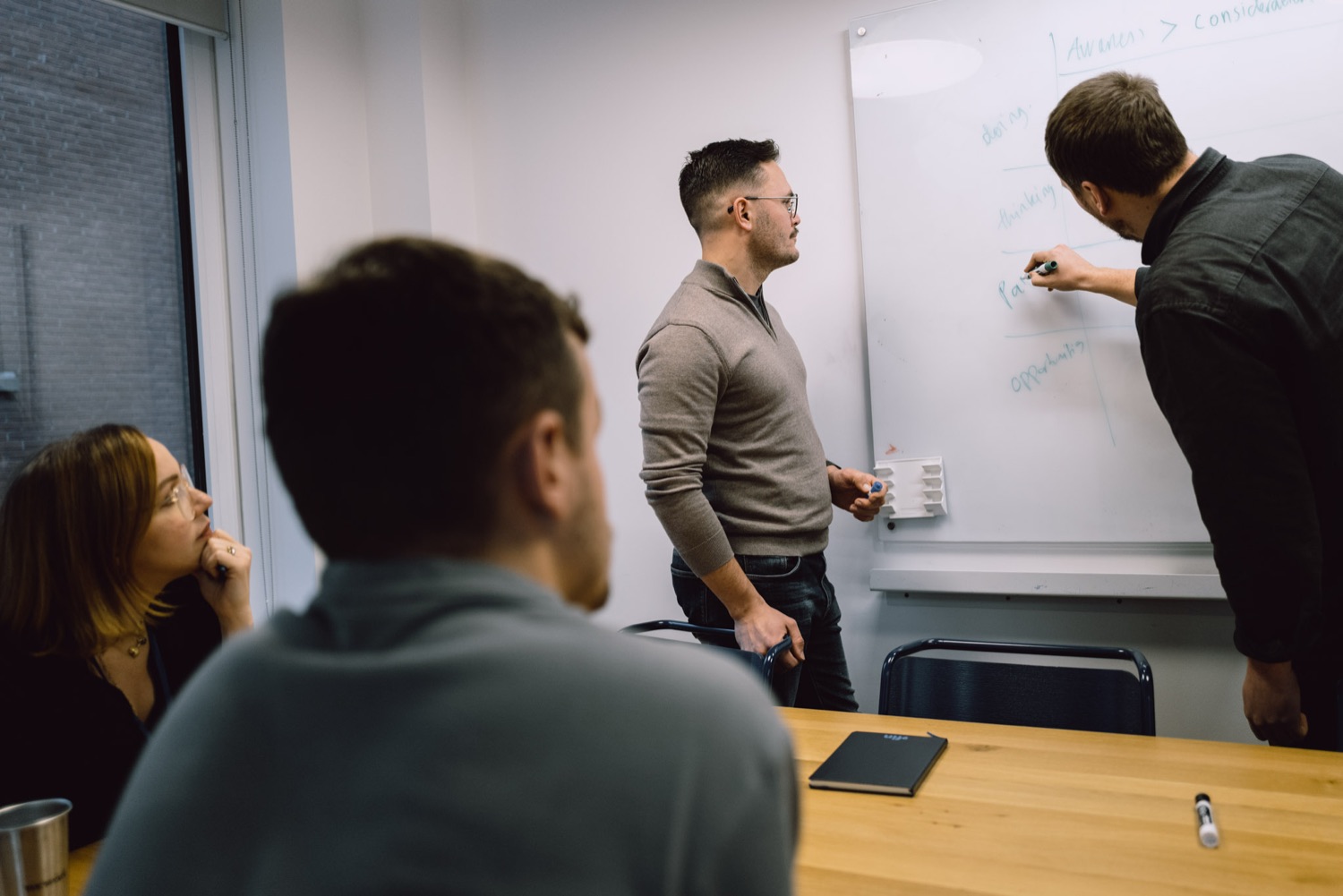 Team workshop at the whiteboard during a company offsite, London