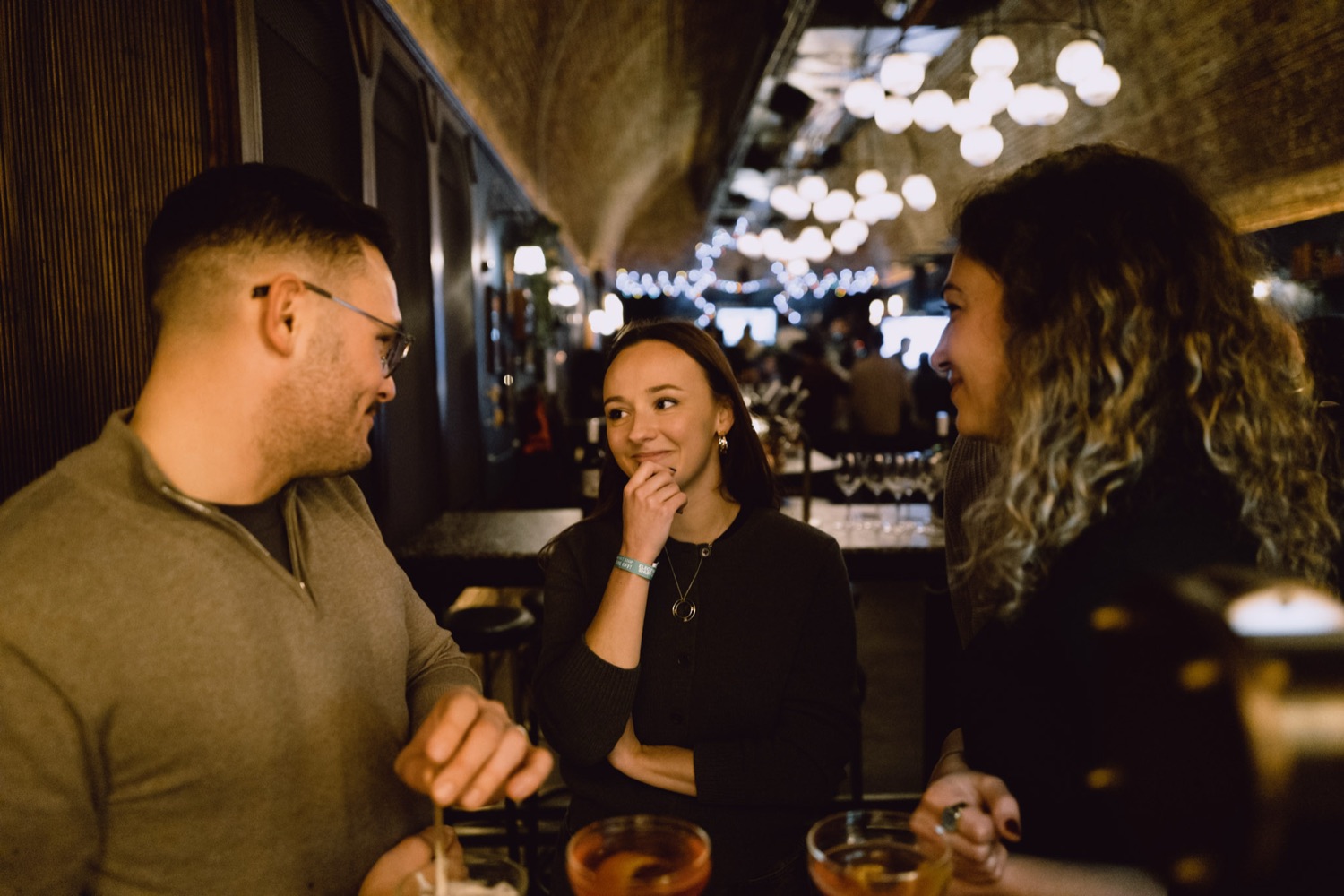 Colleagues sharing a laugh over drinks at a team social, London